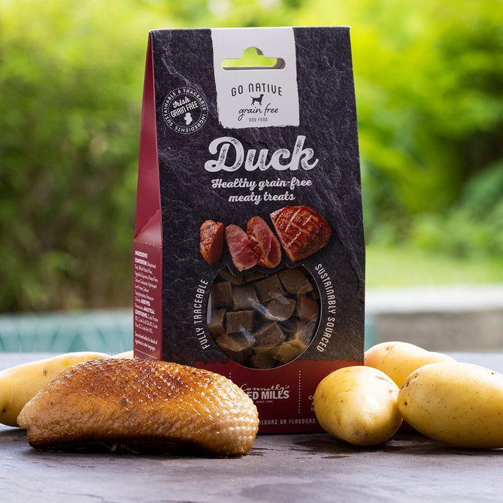 Go Native Duck Dog Treats 100g pack with duck breast and potatoes, outdoor lifestyle shot