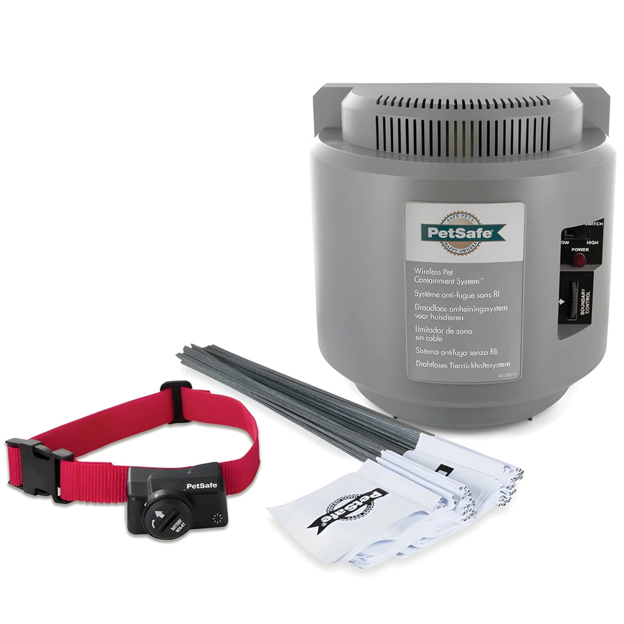 A PetSafe wireless radio fence system including a grey transmitter, a red and black receiver collar, a power adaptor, a test light tool, and a operating & training guide.