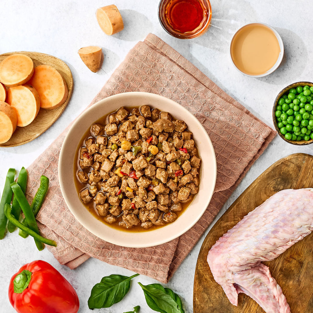 Naturo Turkey in Herb Gravy served in a bowl with turkey, sweet potato, peas and peppers